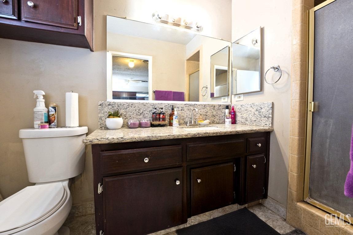 Undisclosed Address Bakersfield, CA 93309 - Photo 20 of 37 a bathroom with a granite countertop sink and a mirror