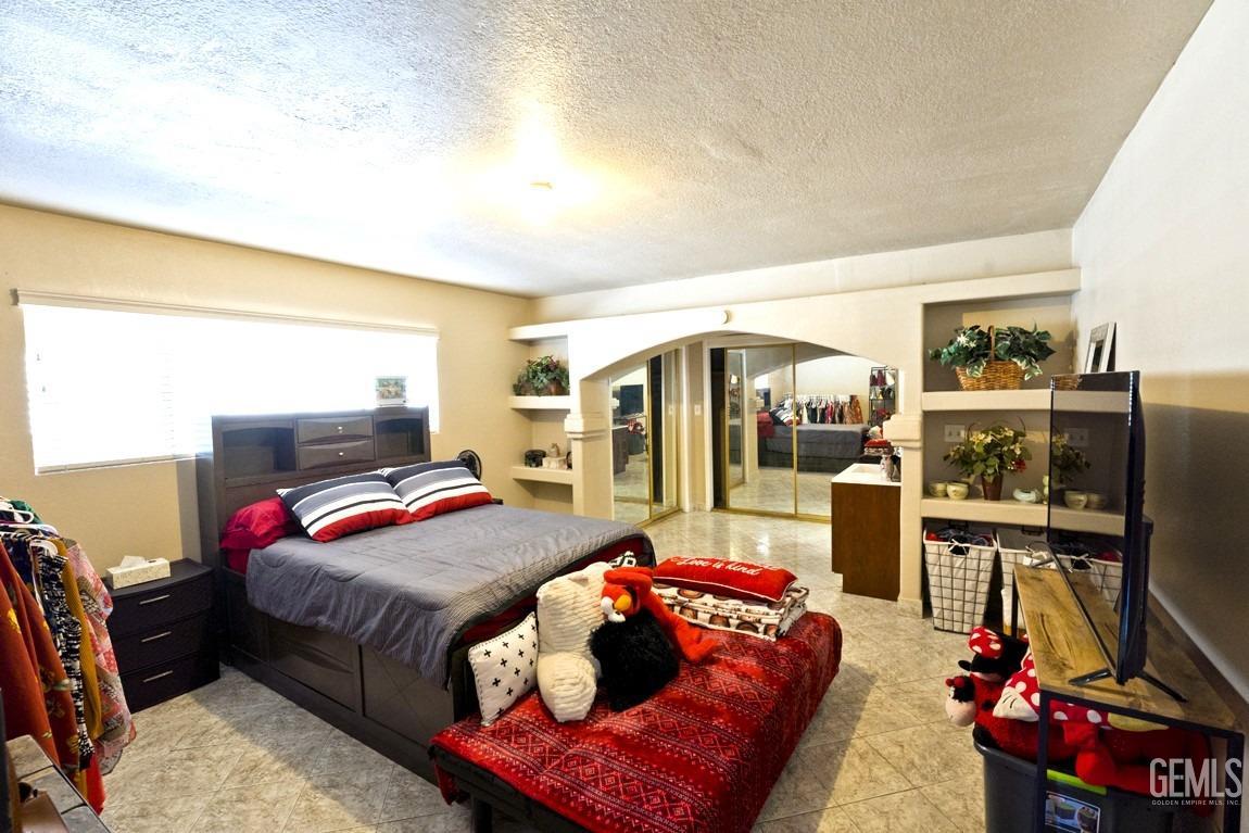 Undisclosed Address Bakersfield, CA 93309 - Photo 21 of 37 a bedroom with furniture and a flat screen tv