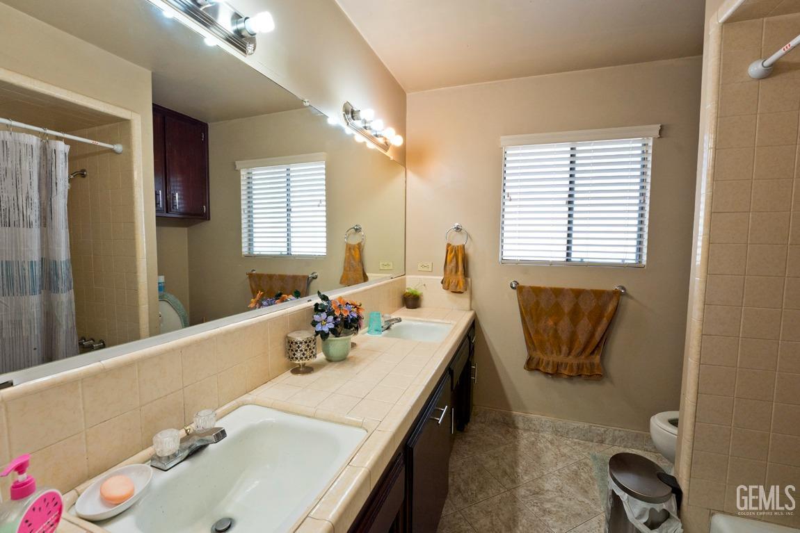 Undisclosed Address Bakersfield, CA 93309 - Photo 22 of 37 a bathroom with a tub sink and mirror