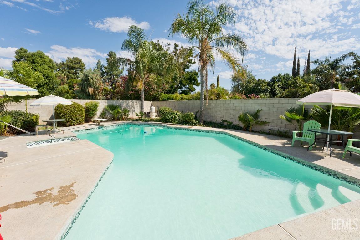Undisclosed Address Bakersfield, CA 93309 - Photo 30 of 37 a view of a swimming pool with lawn chairs under an umbrella