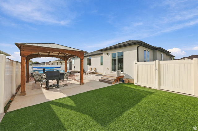 615 West 1870th Street South Payson, UT 84651 - Photo 25 of 31 Expansive outdoor space featuring a wood pergola, concrete patio, artificial turf, and a private fence