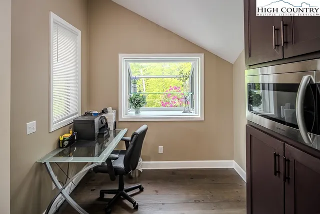 a view of a workspace with furniture and a window