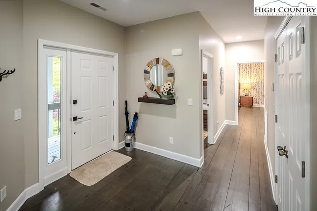 a view of a hallway with wooden floor and closet