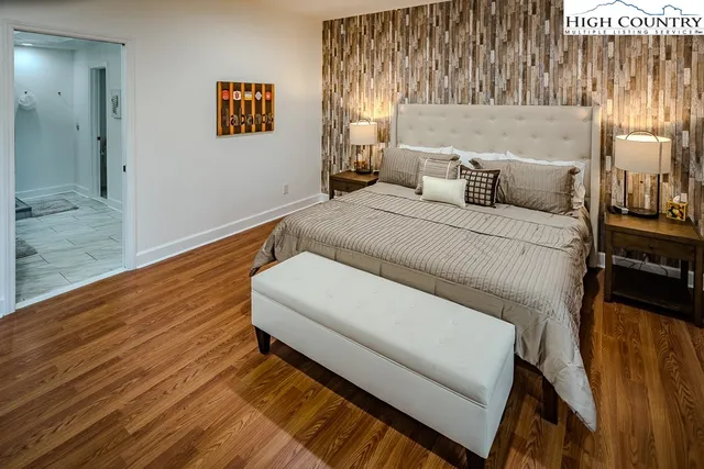 a bedroom with a bed and wooden floor