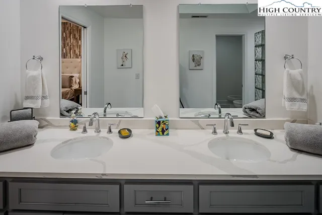 a bathroom with double vanity sinks and a mirror