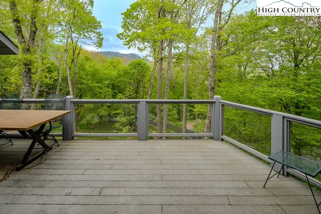 a balcony with wooden floor table and chairs