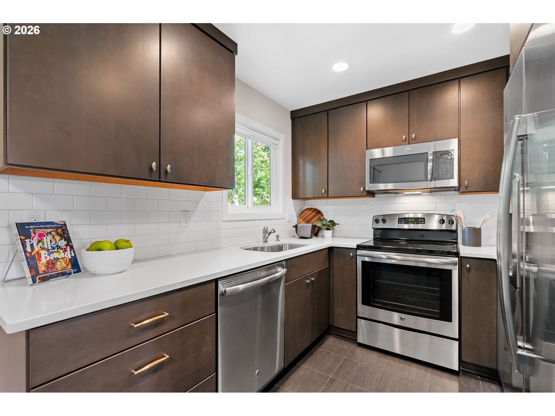 1442 Southwest 66th Avenue Portland, OR 97225 - Photo 9 of 31 a kitchen with stainless steel appliances granite countertop a stove a sink and a microwave