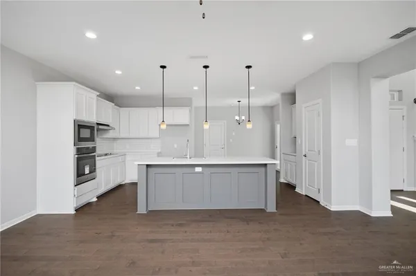 a large kitchen with cabinets and a refrigerator