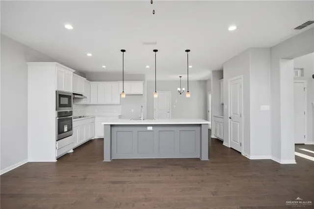 a large kitchen with cabinets and a refrigerator