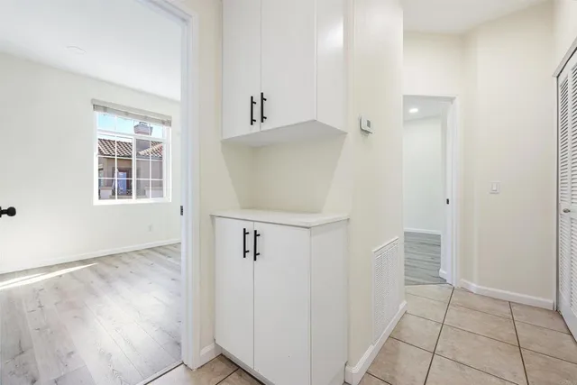 an entryway with wooden floor and cabinet