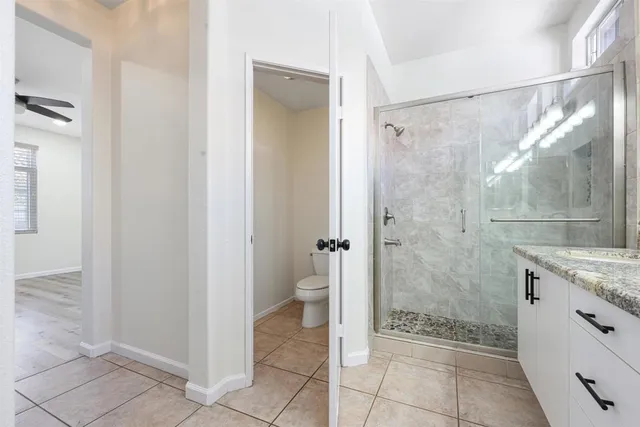 a bathroom with a granite countertop shower a mirror and a sink