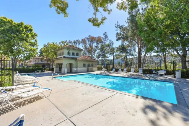 a sign of golf club on a wall under a tree