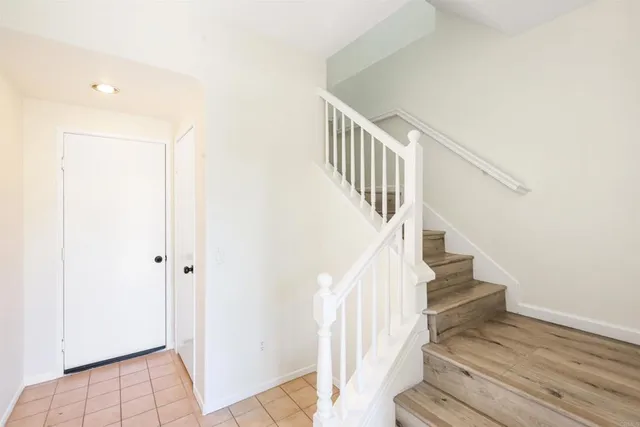a view of staircase with wooden floor and white walls