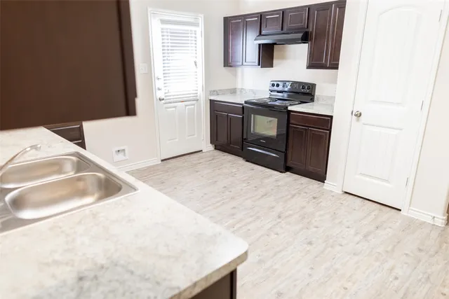 a kitchen with stainless steel appliances granite countertop a sink and a stove