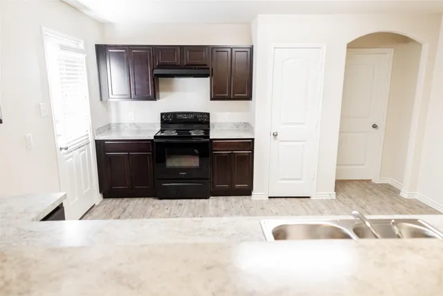 a kitchen with stainless steel appliances kitchen island granite countertop a stove and a refrigerator