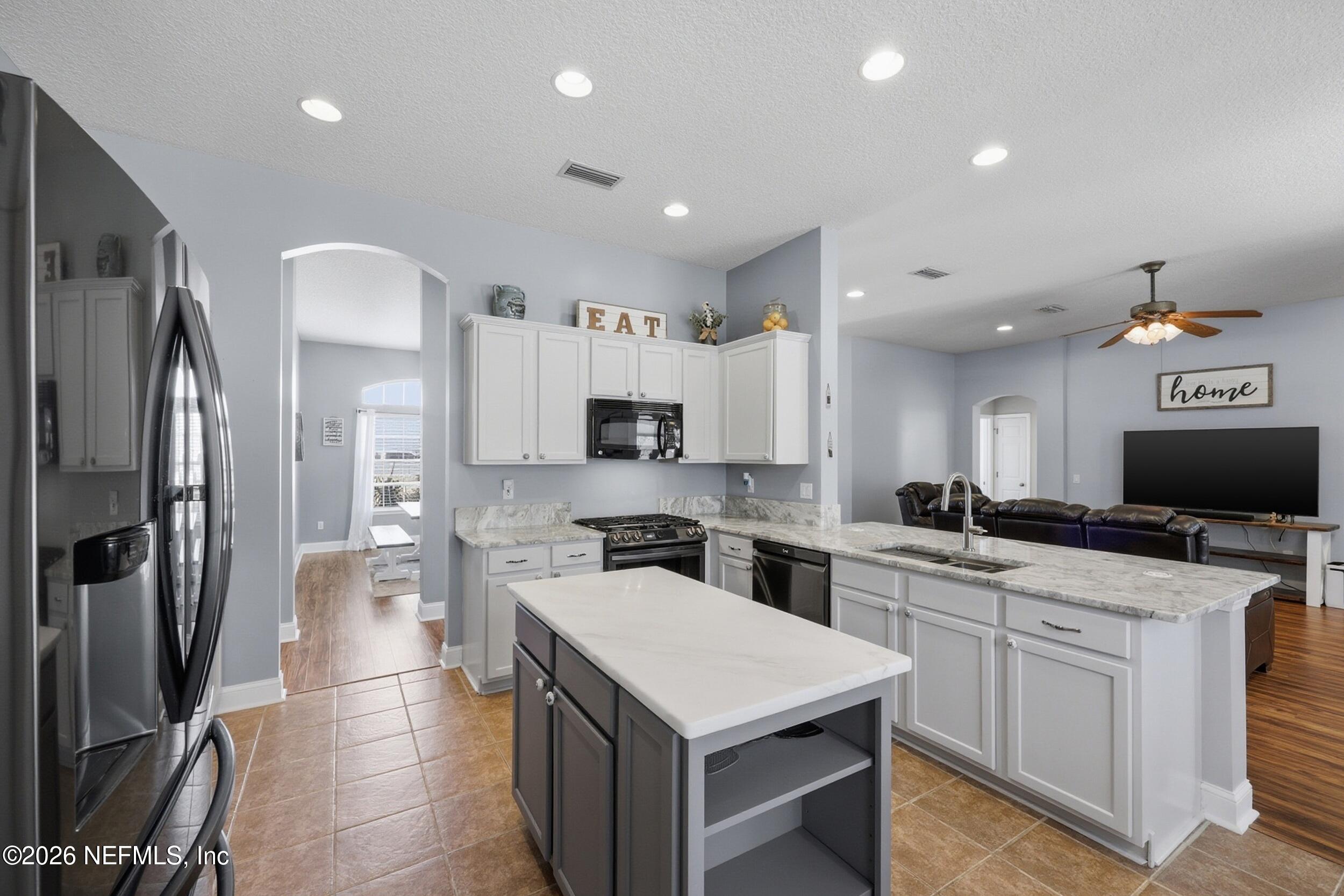 44808 Green Meadows Lane Callahan, FL 32011 - Photo 7 of 41 a kitchen with a sink a counter top space stainless steel appliances and cabinets
