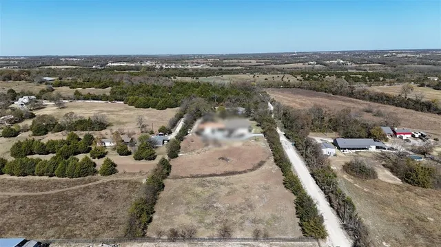 an aerial view of a house with a mountain