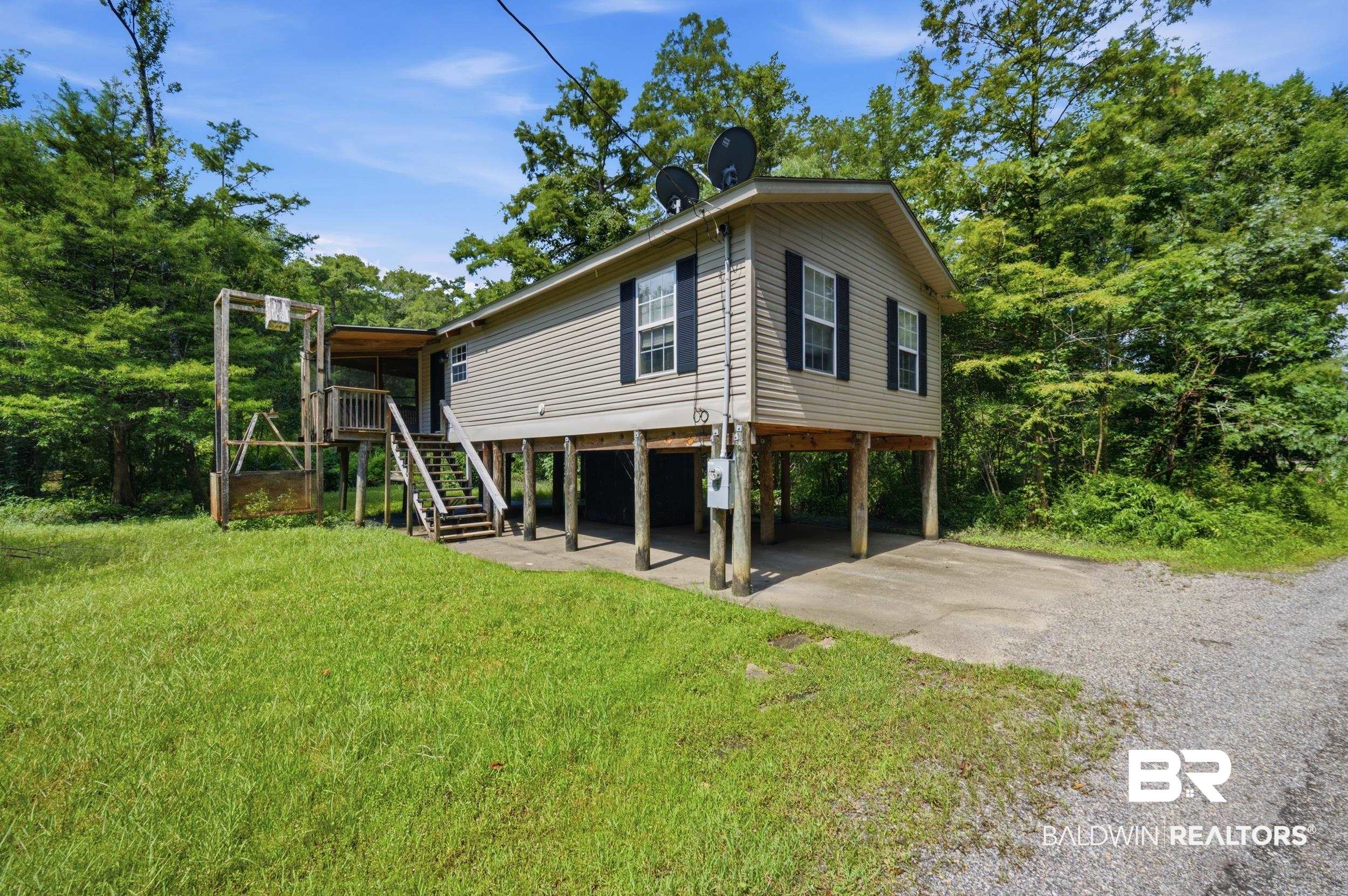 42080 Bayou Road Bay Minette, AL 36507 - Photo 4 of 43 Elevated residence featuring neutral siding and dark window shutters