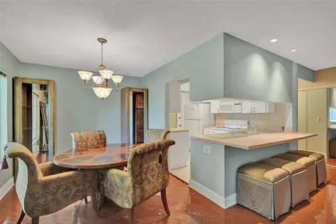 a view of kitchen with granite countertop dining table chairs and a chandelier
