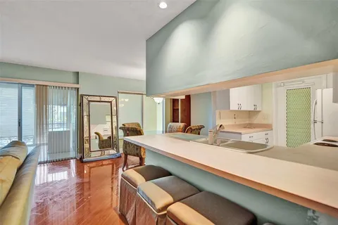 a large dining hall with stainless steel appliances granite countertop a couch and cabinets