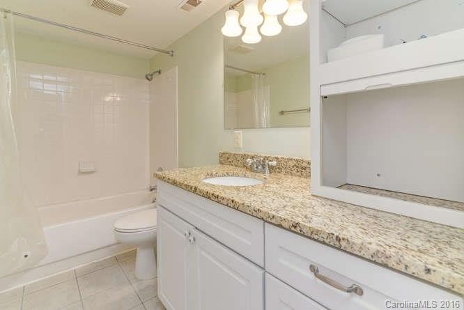 79 Maple Ridge Lane, Unit 79 Asheville, NC 28806 - Photo 12 of 20 a bathroom with a granite countertop sink a toilet and bathtub