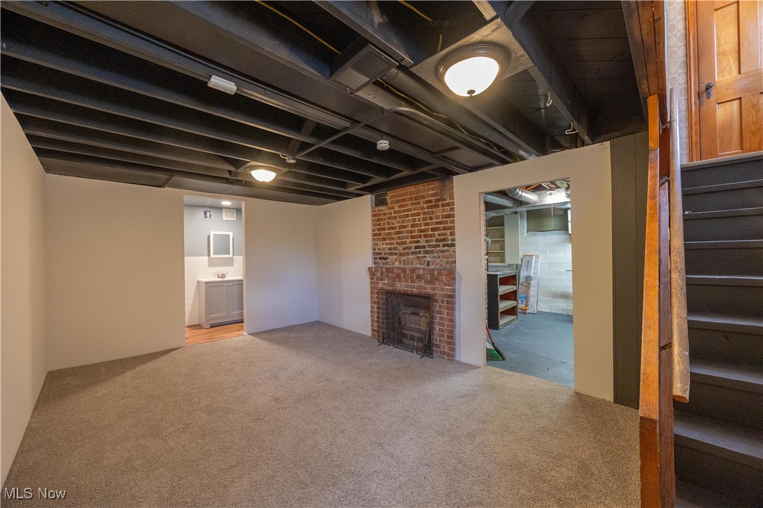 3797 Northwood Road Cleveland, OH 44118 - Photo 36 of 49 Finished below grade area with stairs, light colored carpet, and a fireplace