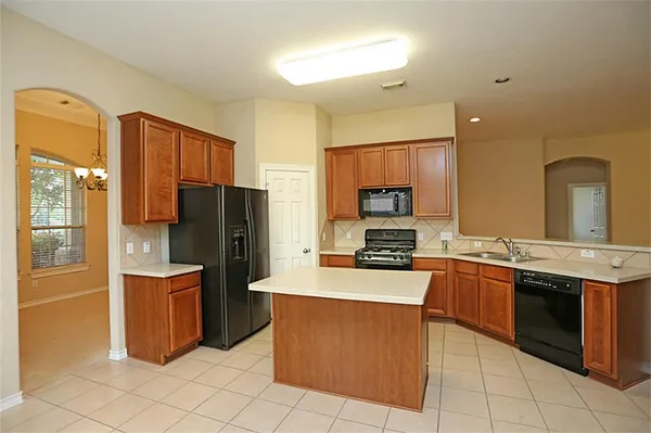 a kitchen with stainless steel appliances granite countertop a refrigerator stove and sink