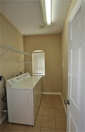 a view of an empty room with a chandelier fan