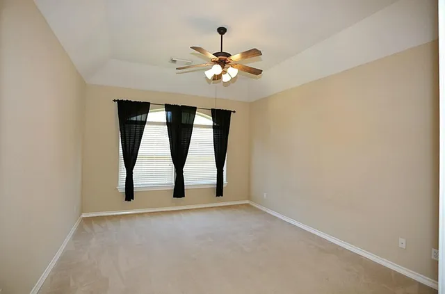 a view of an empty room with a chandelier fan