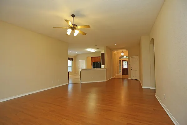 a view of an empty room with window and wooden floor