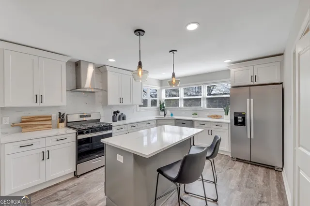 a kitchen with a refrigerator a stove a sink and white cabinets with wooden floor