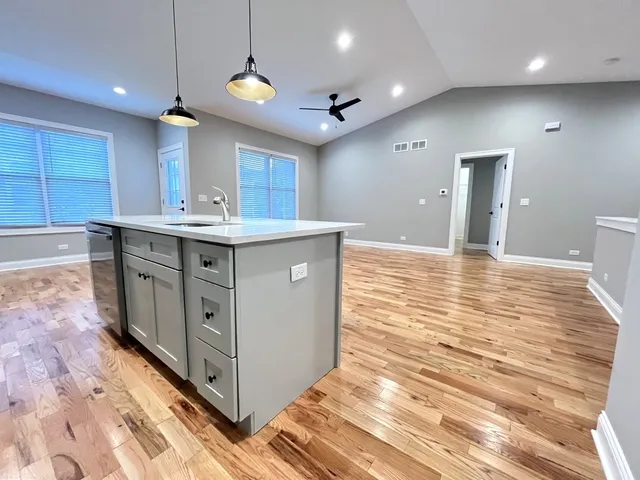 a kitchen with kitchen island a sink stainless steel appliances and cabinets