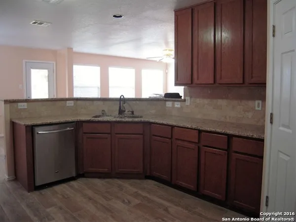 a kitchen with granite countertop cabinets and window