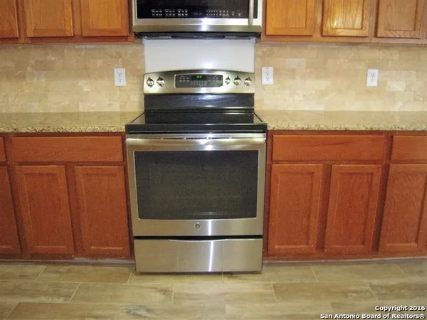 a stove top oven sitting inside of a kitchen