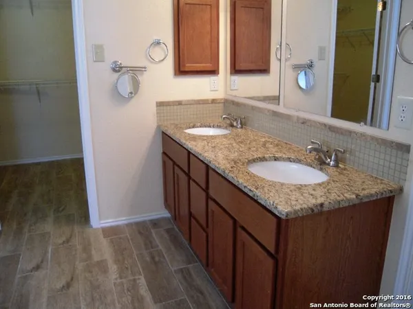 a bathroom with a granite countertop sink and a mirror