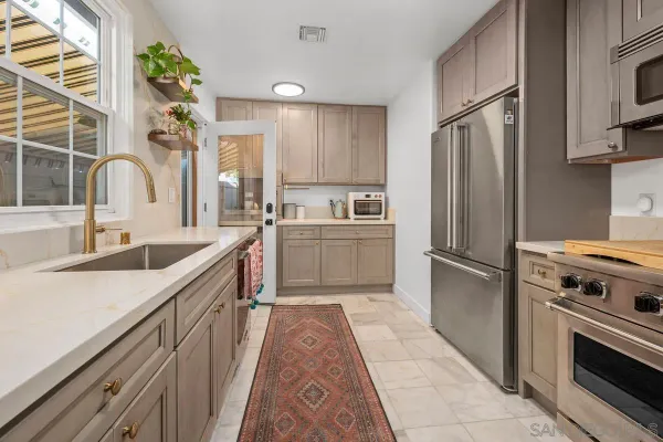 a kitchen with white cabinets and stainless steel appliances