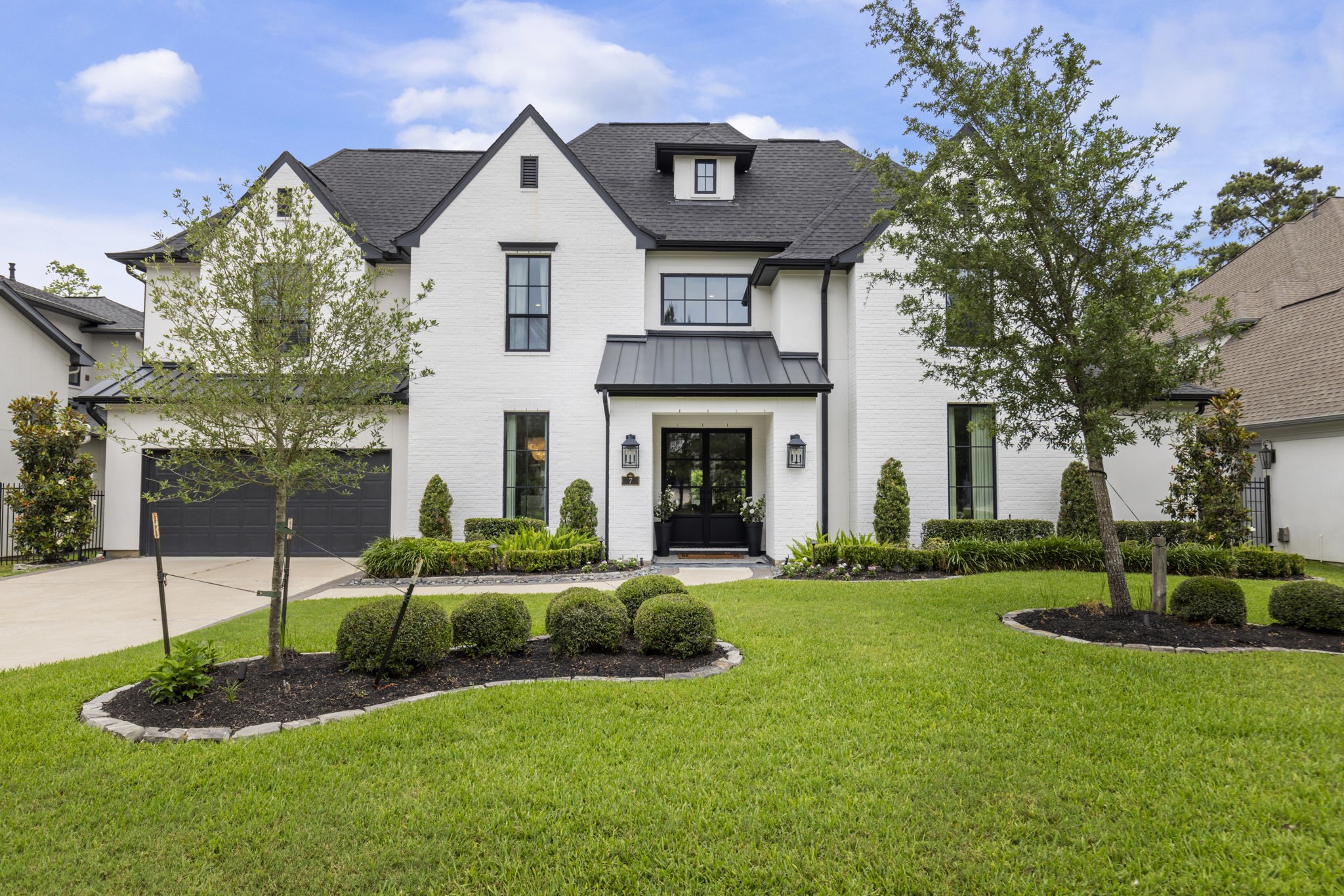 a front view of a house with a garden and plants