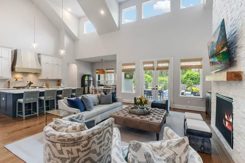 a living room with furniture fireplace and a large window