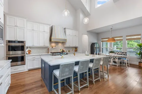 a kitchen with appliances a table and chairs in it