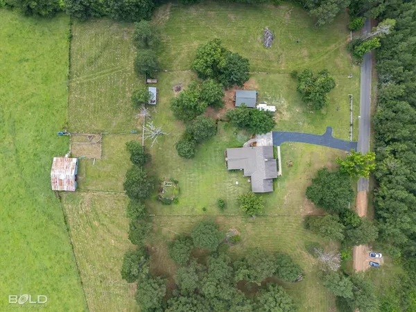an aerial view of residential house with outdoor space and trees all around