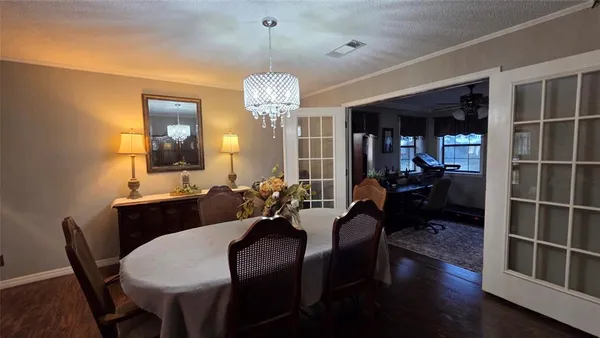 a view of a dining room with furniture a chandelier and wooden floor