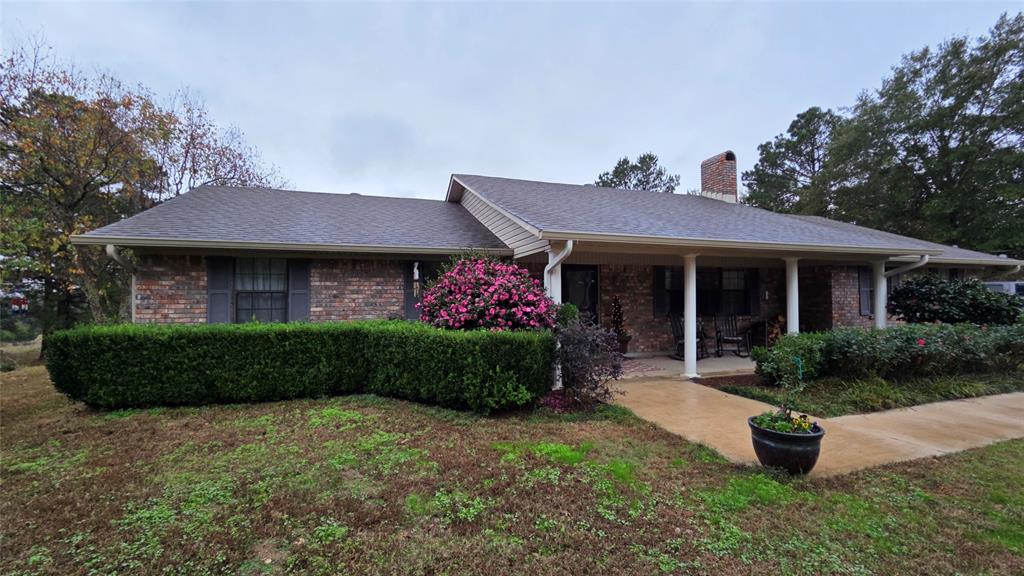 236 Charlie Cannon Road Coushatta, LA 71019 - Photo 34 of 39 Ranch-style home featuring a chimney, covered porch, brick siding, and a shingled roof