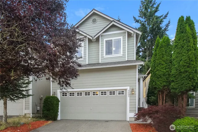a front view of a house with a yard and garage