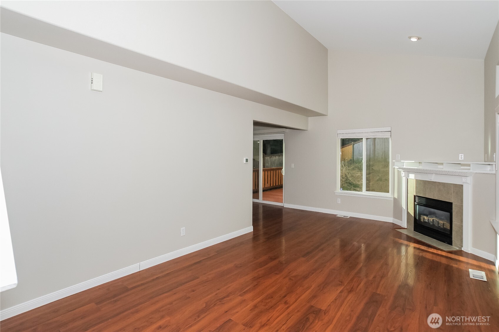 9002 161st Street East Puyallup, WA 98375 - Photo 2 of 17 an empty room with wooden floor fireplace and windows