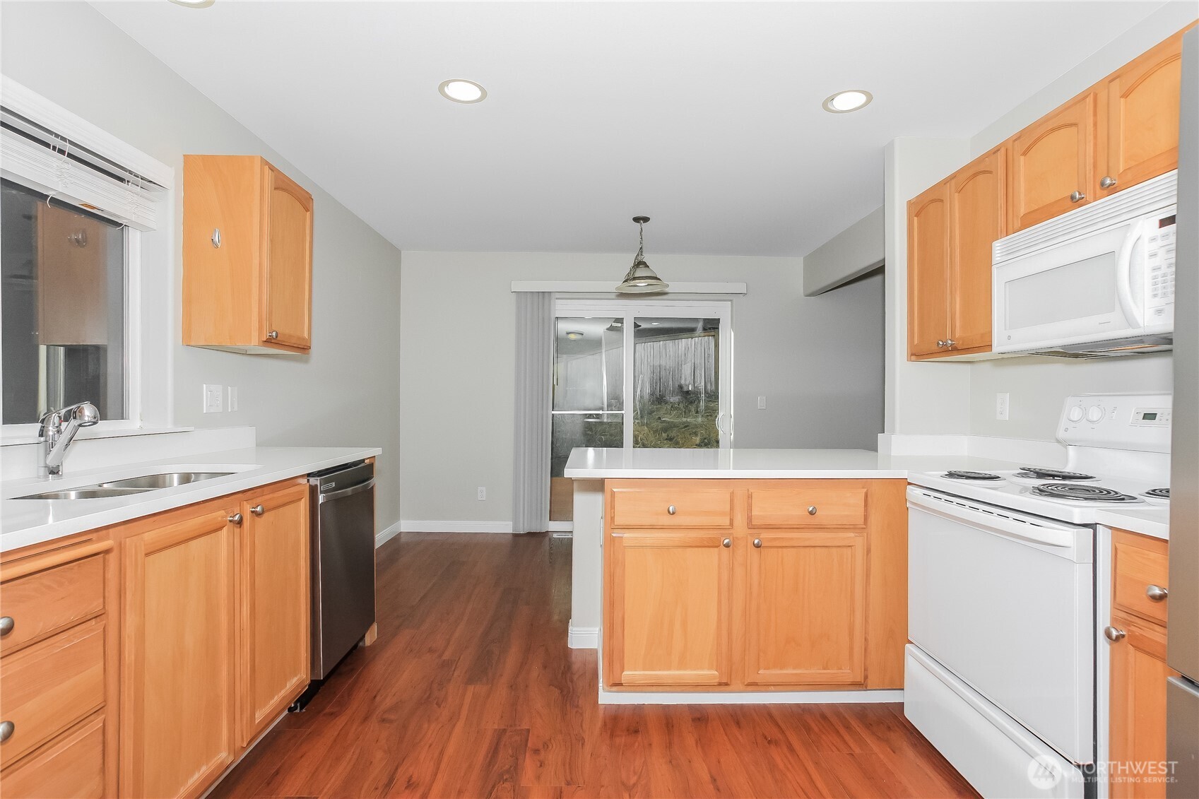 9002 161st Street East Puyallup, WA 98375 - Photo 8 of 17 a kitchen with stainless steel appliances granite countertop wooden cabinets a sink a stove a refrigerator and island with wooden floor