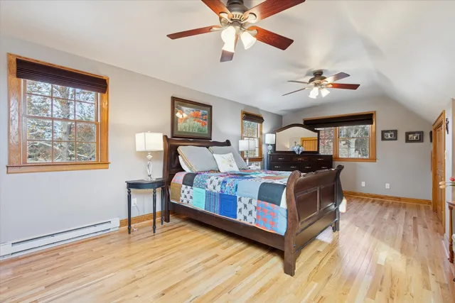 a bedroom with a bed dresser and wooden floor