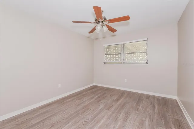 a view of a room with wooden floor and a ceiling fan