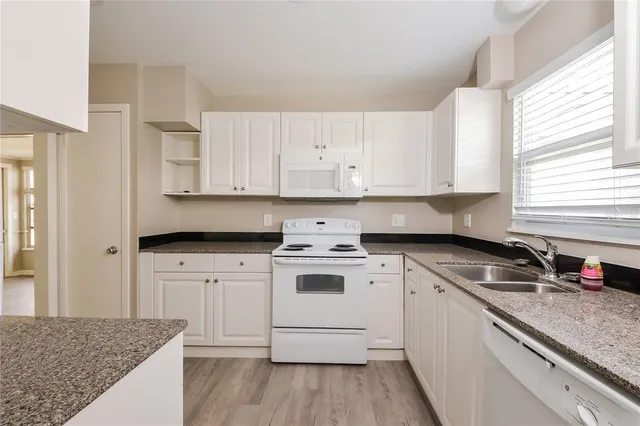 a kitchen with stainless steel appliances granite countertop a sink stove and cabinets