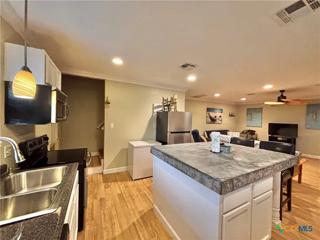 a kitchen with a stove a sink and a refrigerator