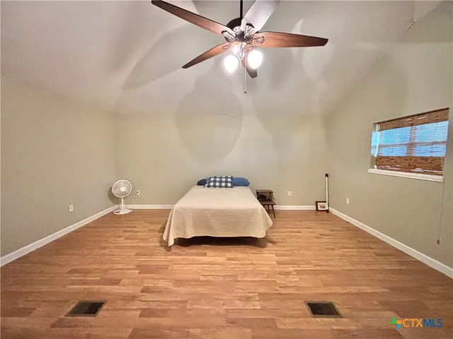 a bedroom with a bed and a ceiling fan